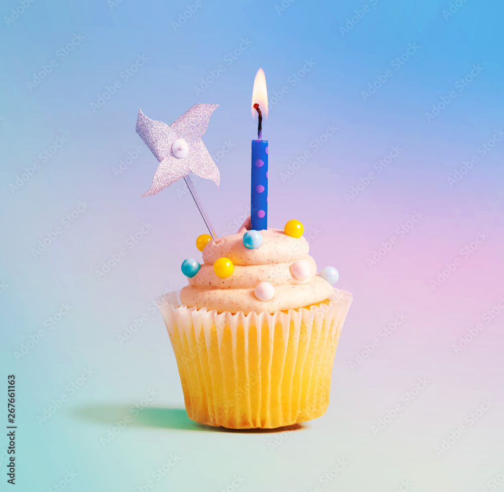 Celebratory cupcake with a decorative lit candle