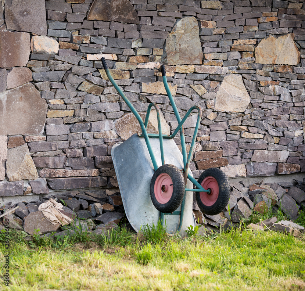 Wheelbarrow near stone house