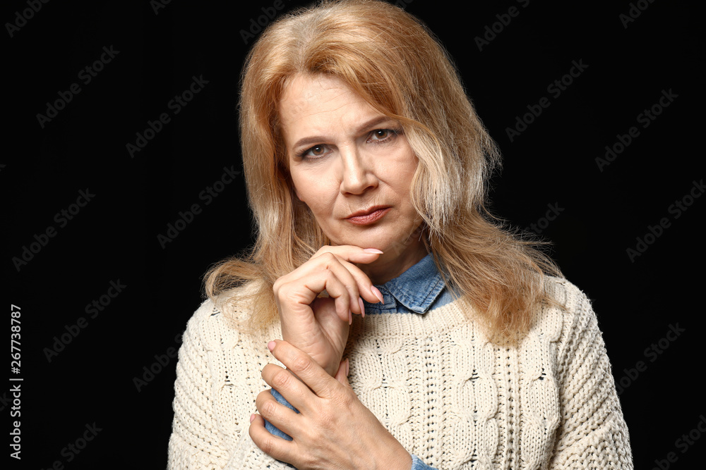 Portrait of thoughtful mature woman on dark background