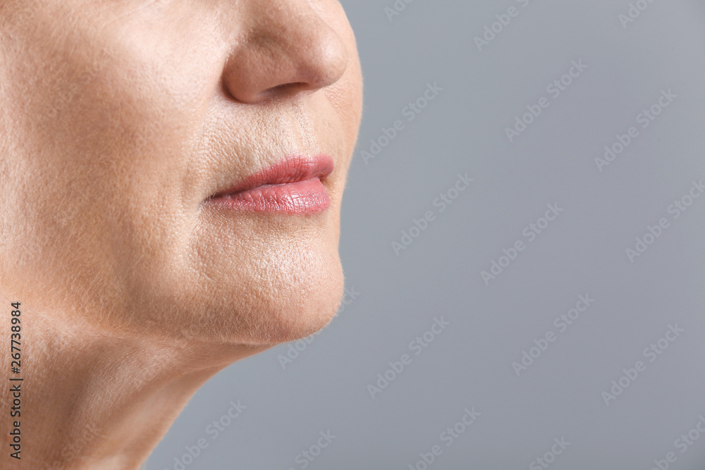 Mature woman on light background, closeup