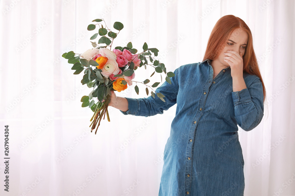 年轻的怀孕妇女带着花束在家中中毒