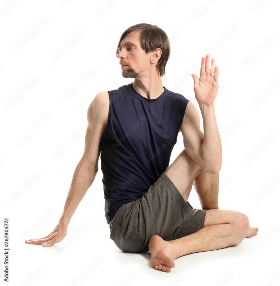 Sporty man practicing yoga on white background