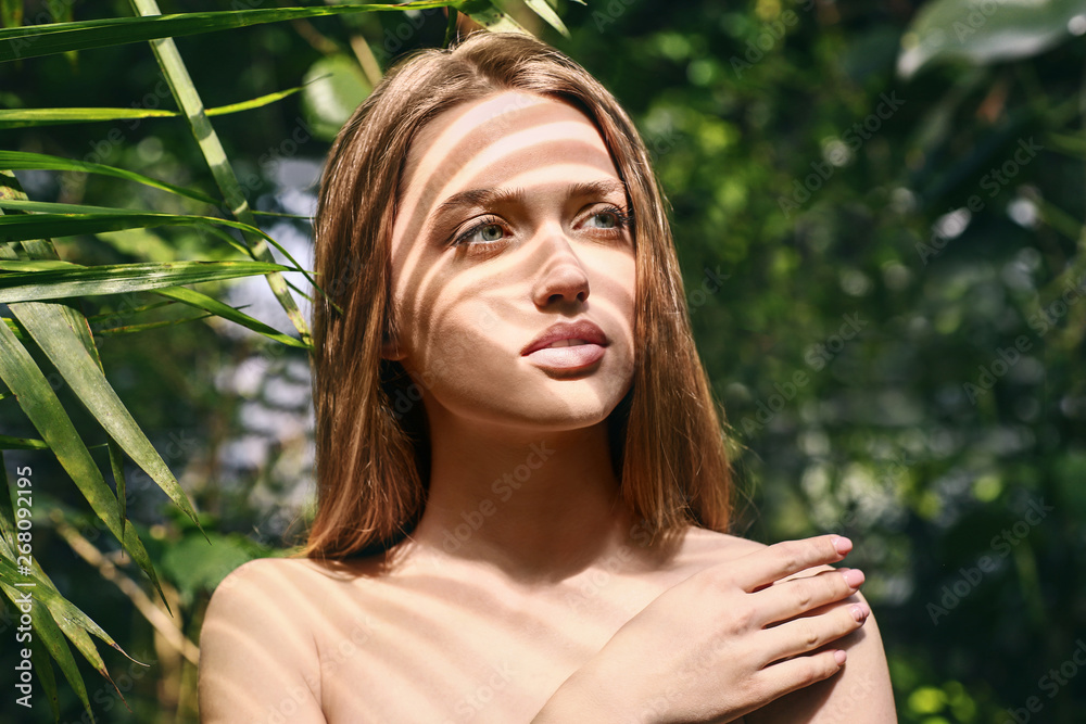 Portrait of beautiful young woman in tropical forest