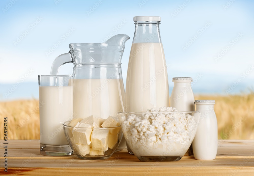 Glass jug of fresh milk  on background