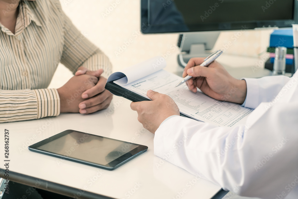 Male doctor explaining diagnosis to patient. Woman patient looking worried when listening bed news.