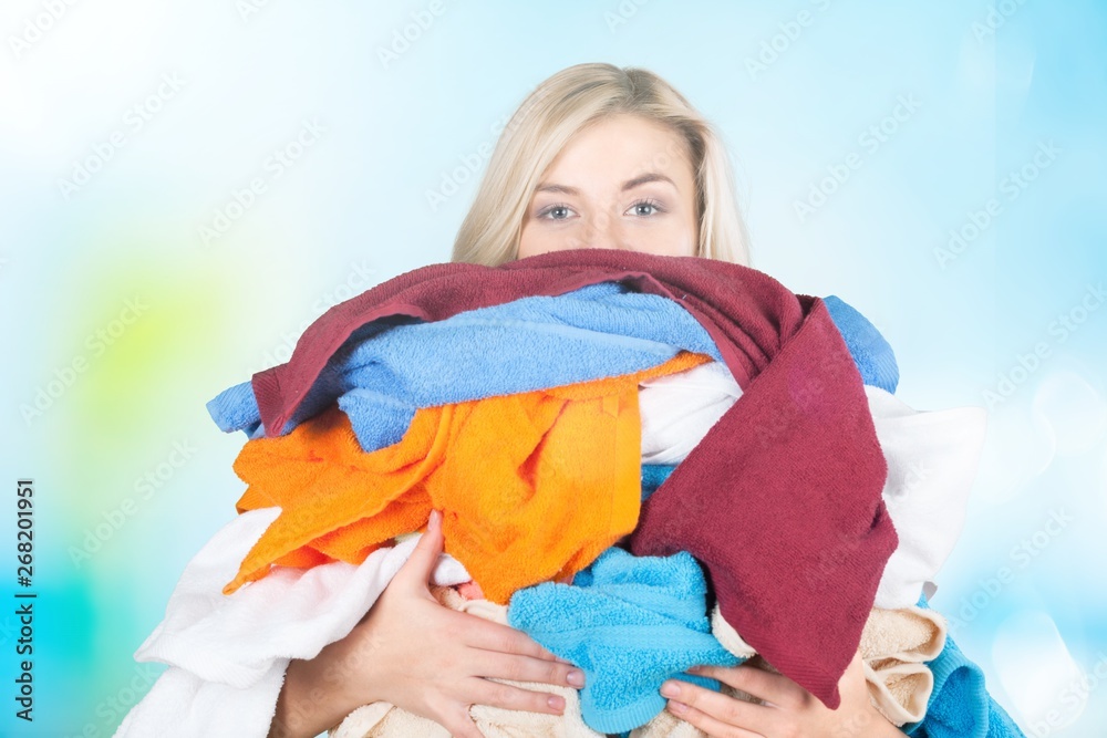 Young Tired Woman Carrying heap of different clothes