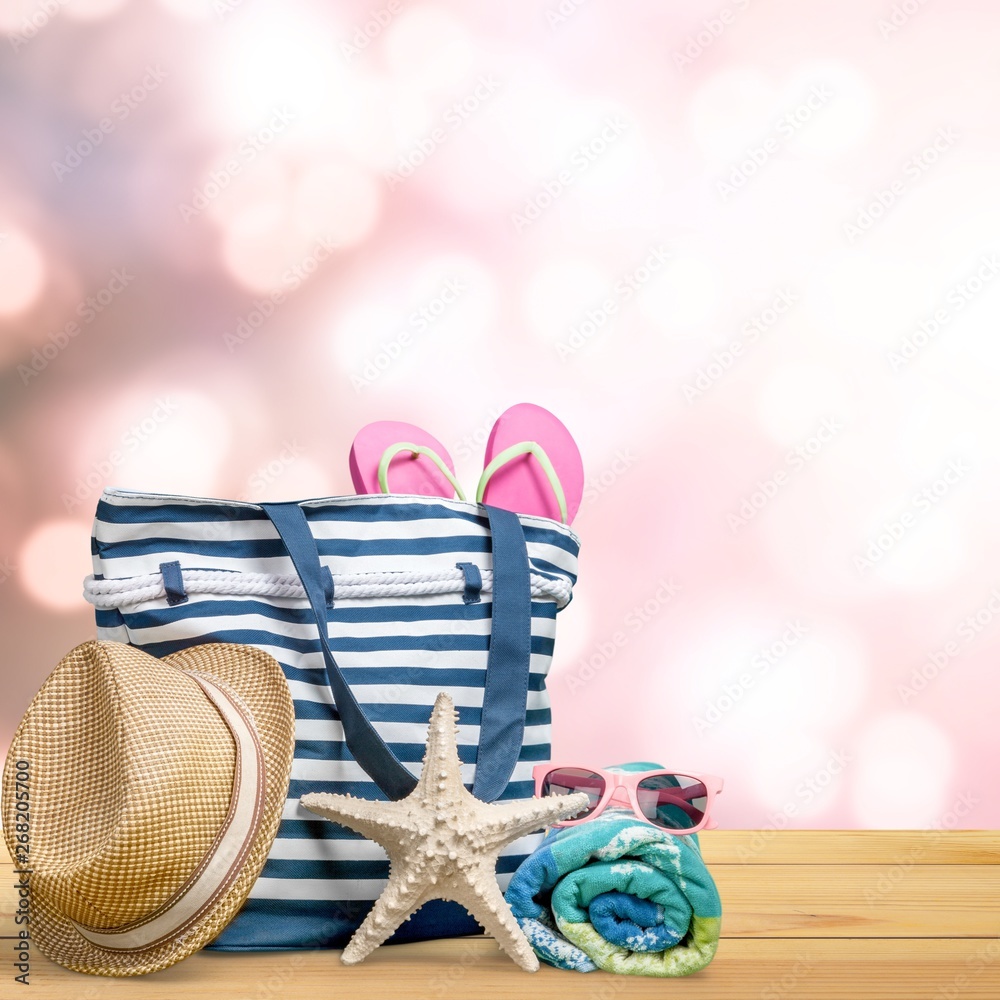 Straw hat, bag,  flip flops on a tropical beach