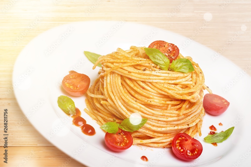 Spaghetti pasta with tomatoes and parsley on  table.