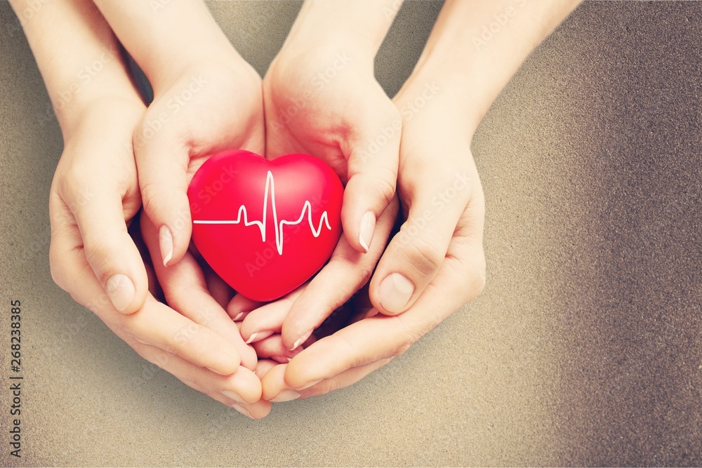 Man and woman holding red heart in