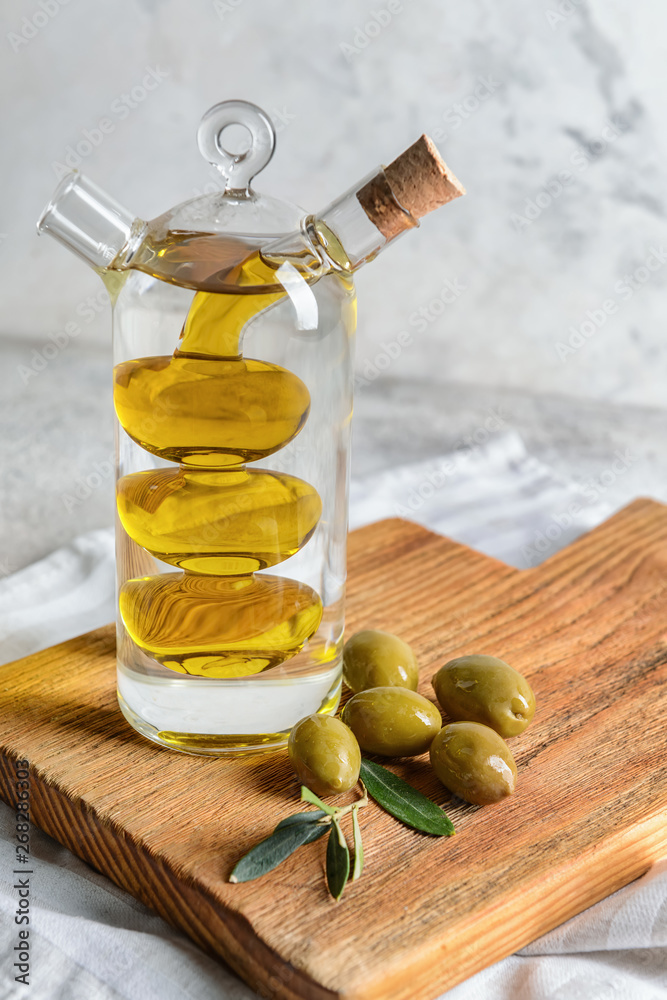 Bottle of tasty olive oil on wooden board