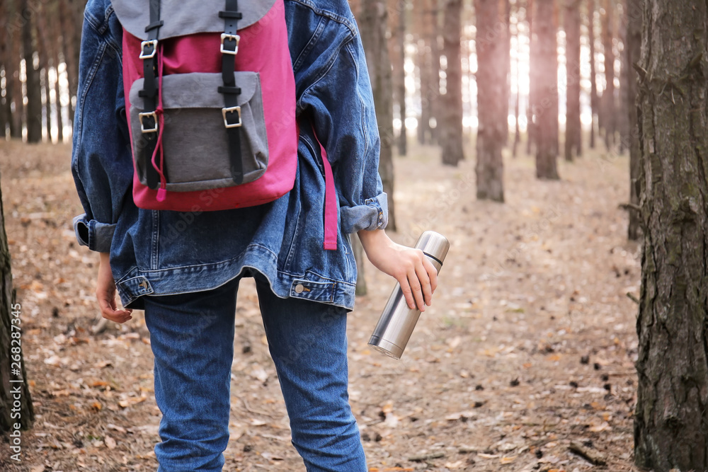 带着保温瓶的女人在森林里旅行