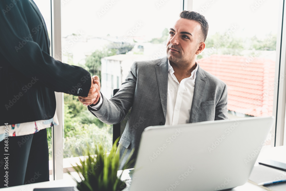 Businessman executive handshake with businesswoman worker in modern workplace office. People corpora