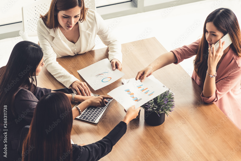 Businesswoman in group meeting discussion with other businesswomen colleagues in modern workplace of