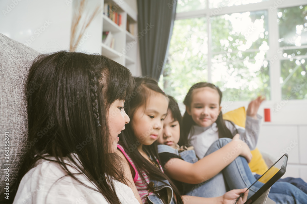 group of little children watching film movie cartoon together on digital tablet. Kids playing with t