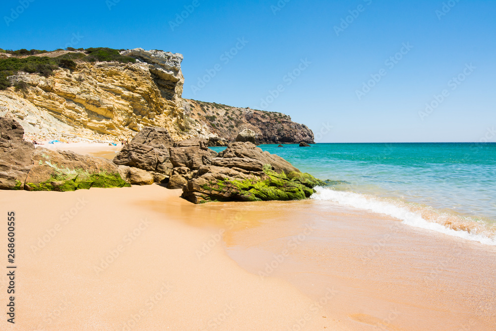 Rocks on sandy Praia do Amado beach, Portugal