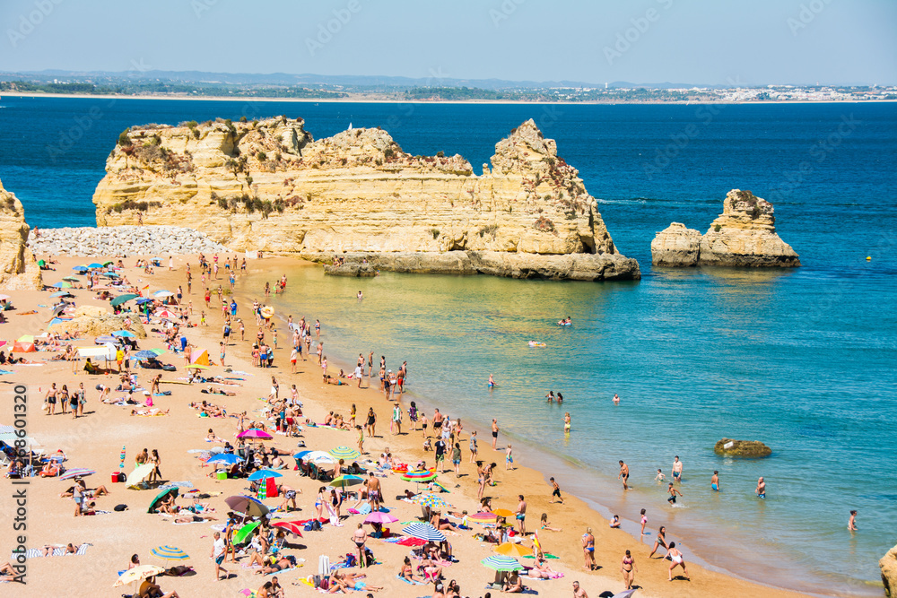 Famous Rocks in Sea, Ocean, Lagos in Portugal. Beach and bathers at Algarve coastline