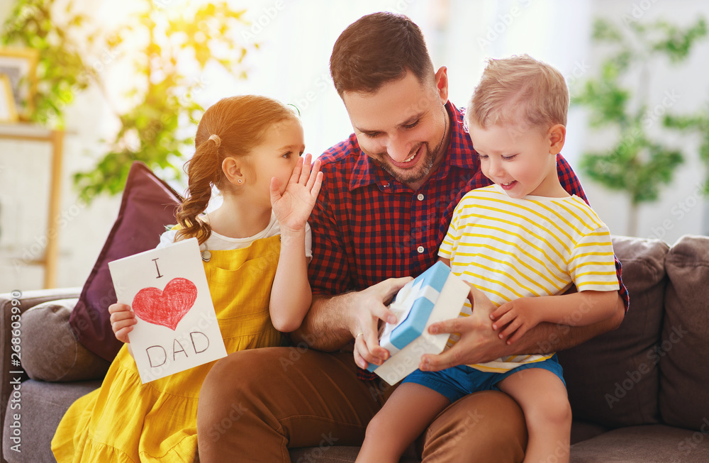 Happy fathers day! Children congratulates dad and gives him gift and postcard