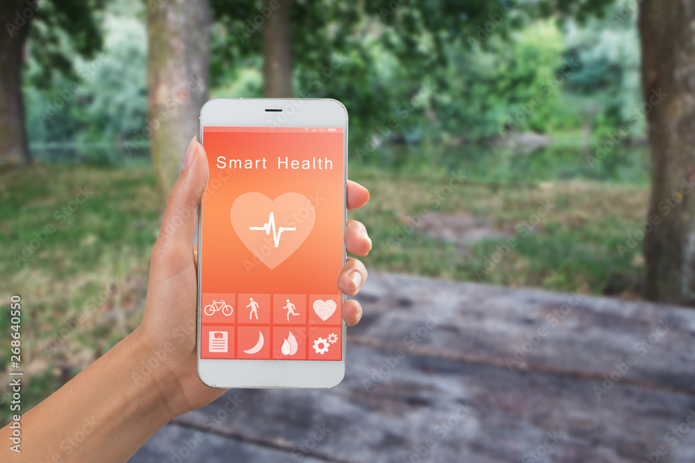 Health monitoring concept - special app on smartphone in a hand outdoors, landscape background