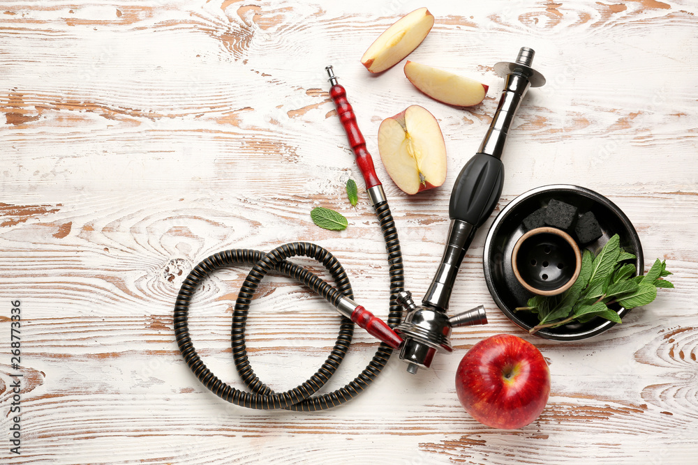 Parts of hookah and apple on wooden background