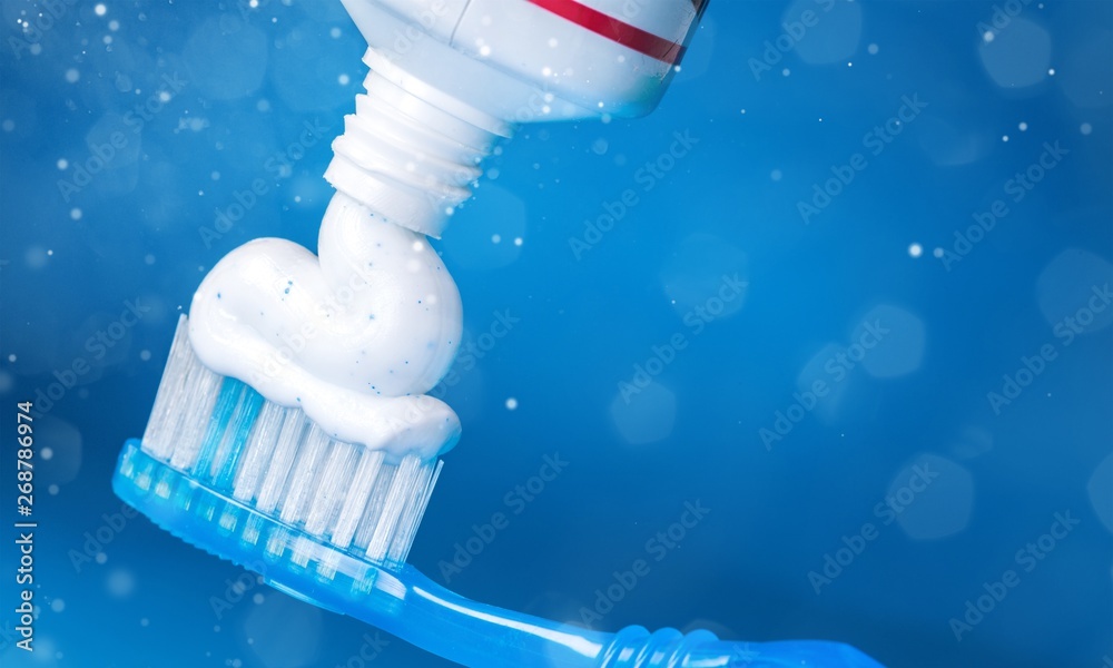 Toothpaste on a toothbrush close-up on background