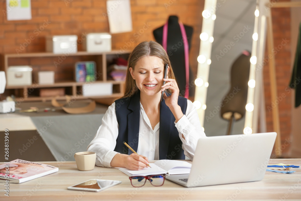 Beautiful female business owner working in atelier