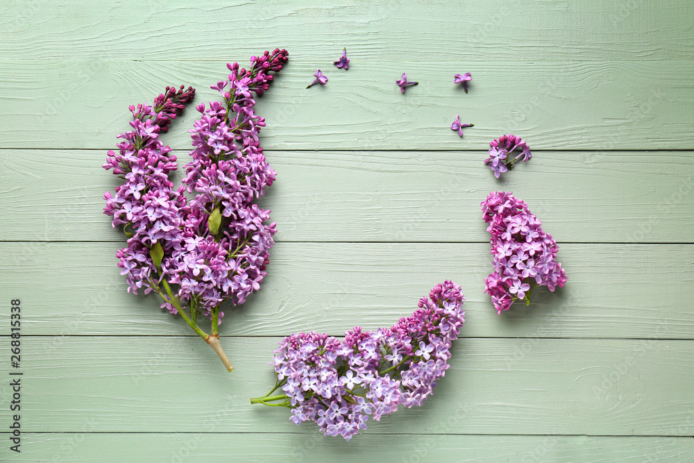 Frame made of beautiful lilac flowers on wooden background