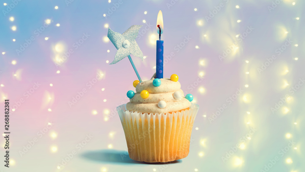 Celebratory cupcake with a decorative lit candle