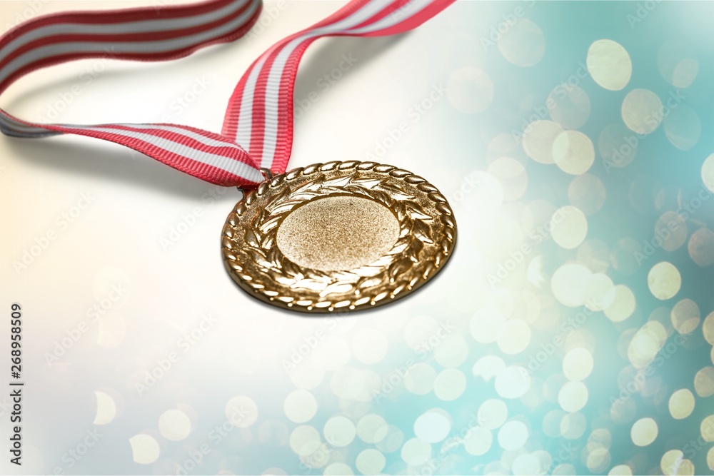 Gold medal with red and white ribbon close-up on gradient background