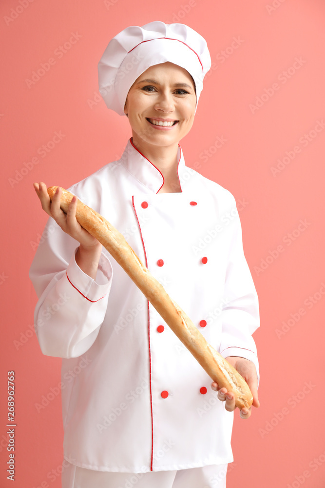 Female baker with bread on color background