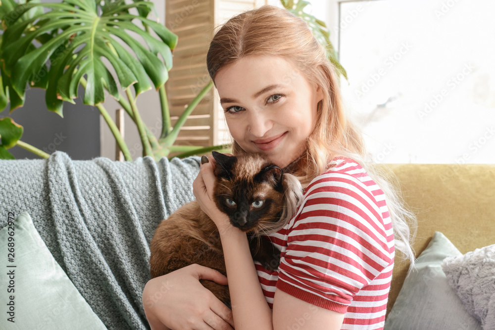 Young woman with cute Thai cat at home