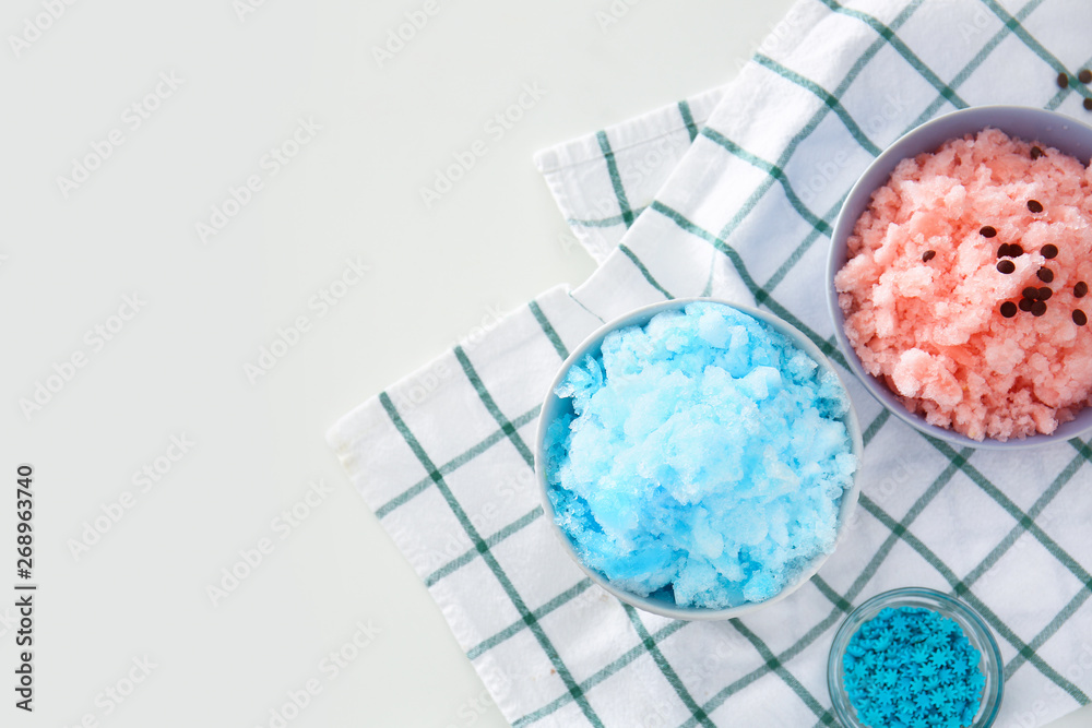 Bowls with different tasty shaved ice on white table