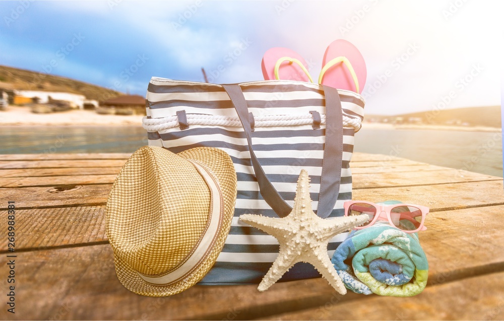 Straw hat, bag,  flip flops on a tropical beach