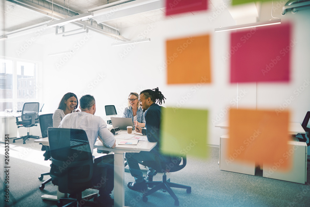 Diverse colleagues meeting together inside of a glass walled off