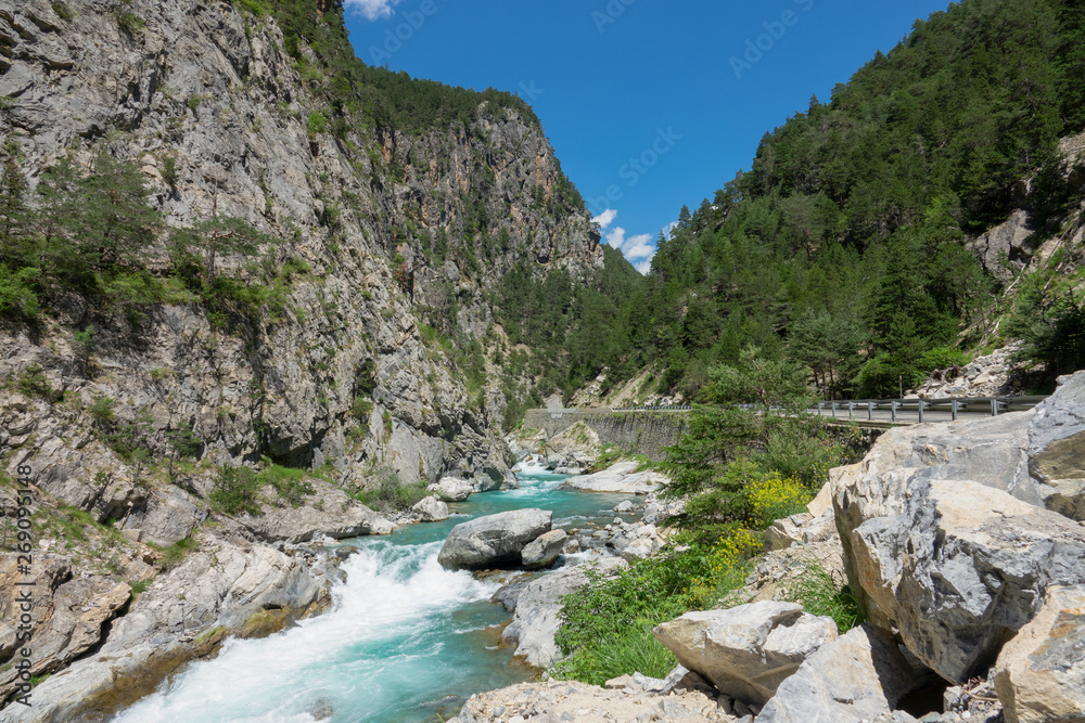 美丽的翡翠河沿着法国阿尔卑斯山空旷的柏油路奔腾而过。