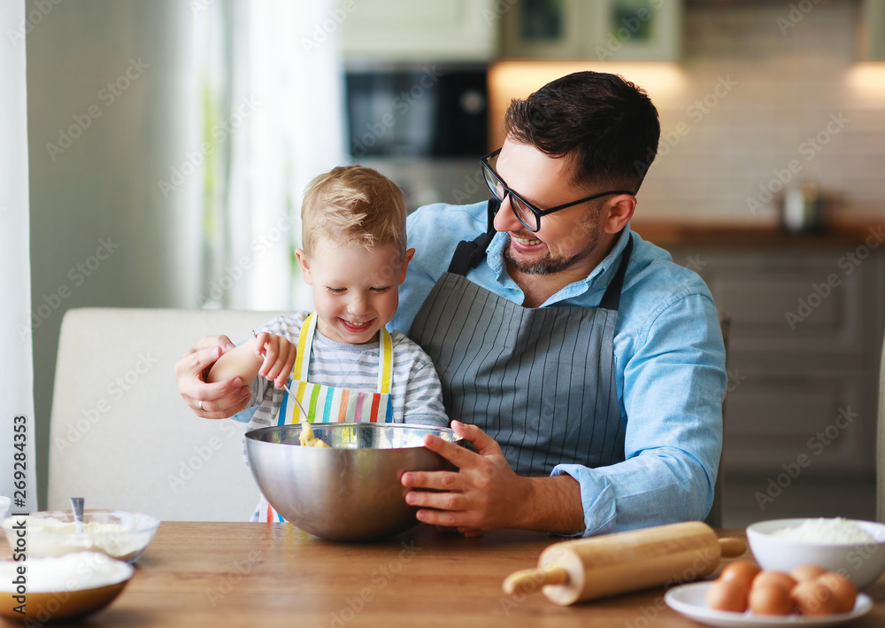 happy family in kitchen. father and child baking cookies