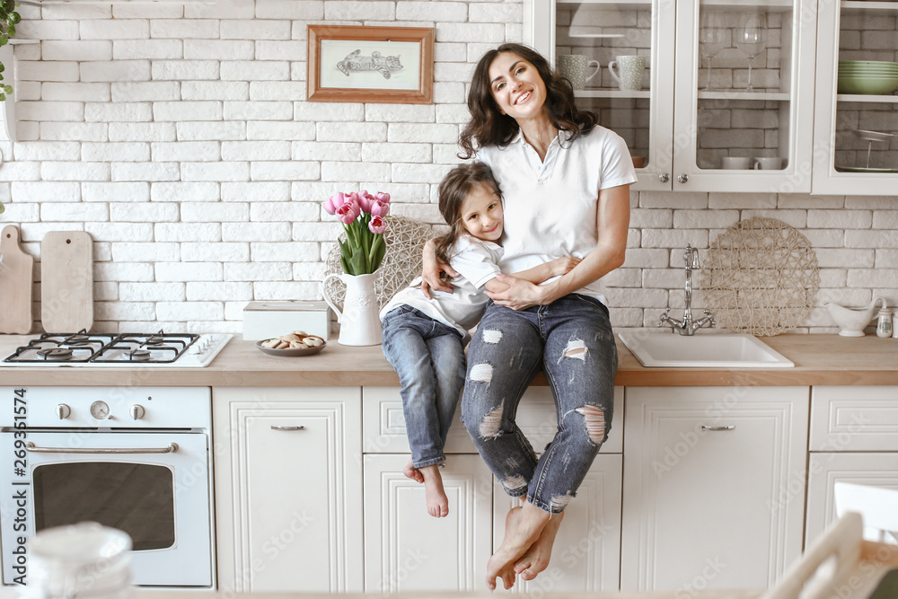 Happy mother with daughter in kitchen at home