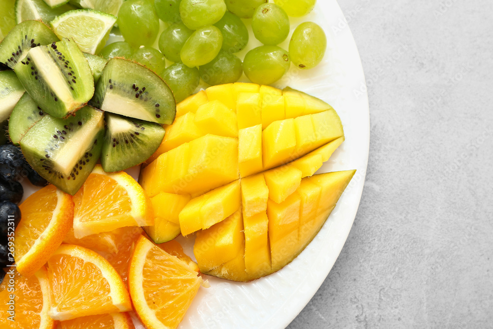 Tasty mango with fresh fruits on plate