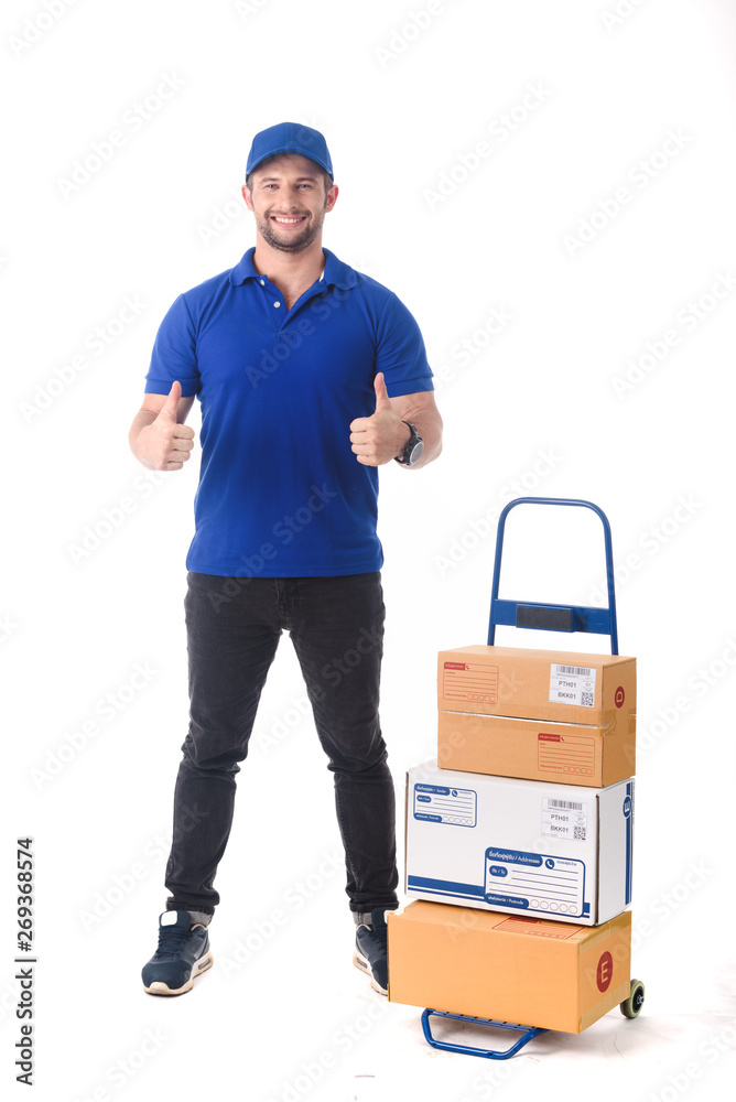 Delivery man in blue uniform of delivery service with trolley, online shopping delivery concept