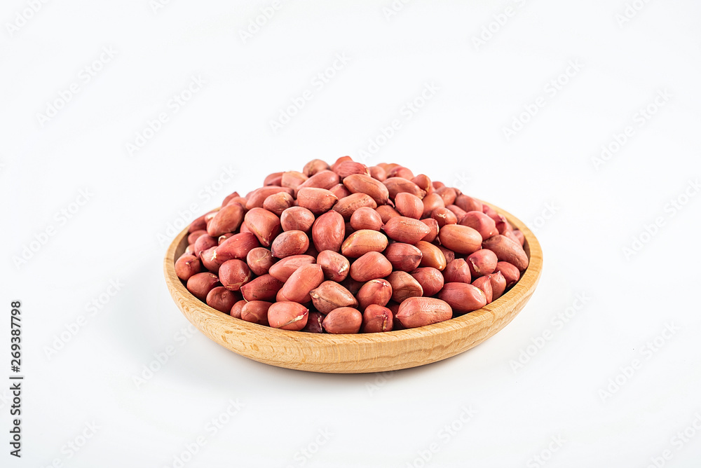 Dried red peanuts in a saucer on a white background