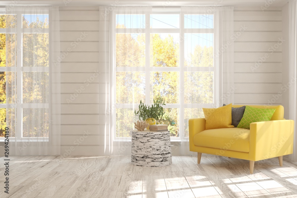 Stylish room in white color with armchair and autumn landscape in window. Scandinavian interior desi