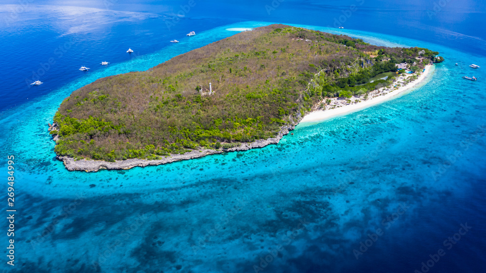 Aerial view of the Sumilon island, sandy beach with tourists swimming in beautiful clear sea water o