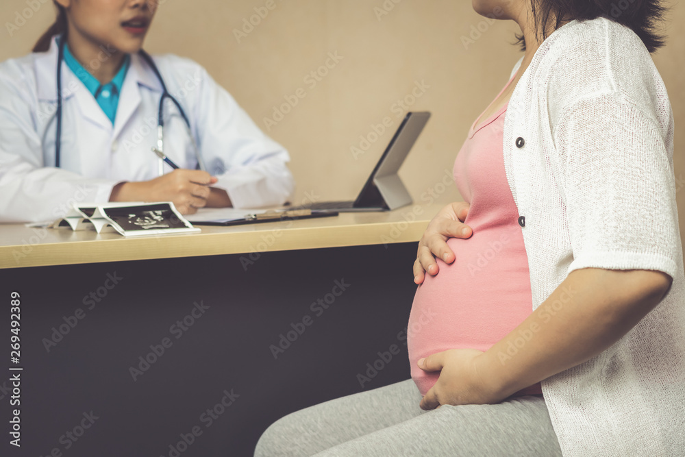 Happy pregnant woman visit gynecologist doctor at hospital or medical clinic for pregnancy consultan