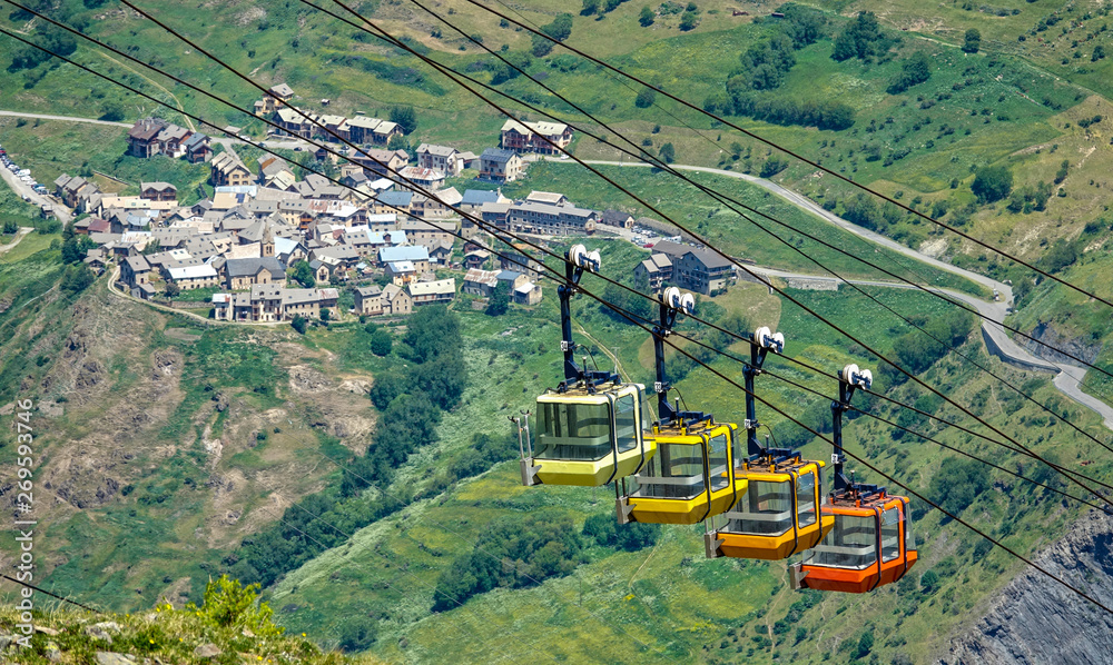 CLOSE UP: Colorful cable cars move above the old ski town in the French Alps.