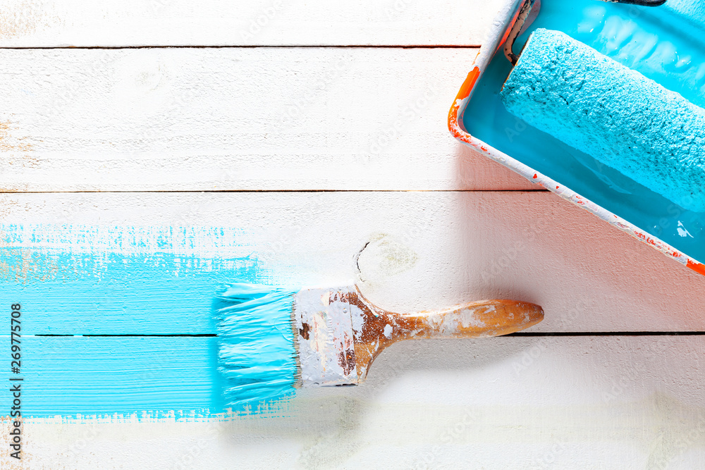 Paint brush with color tray on white wooden background