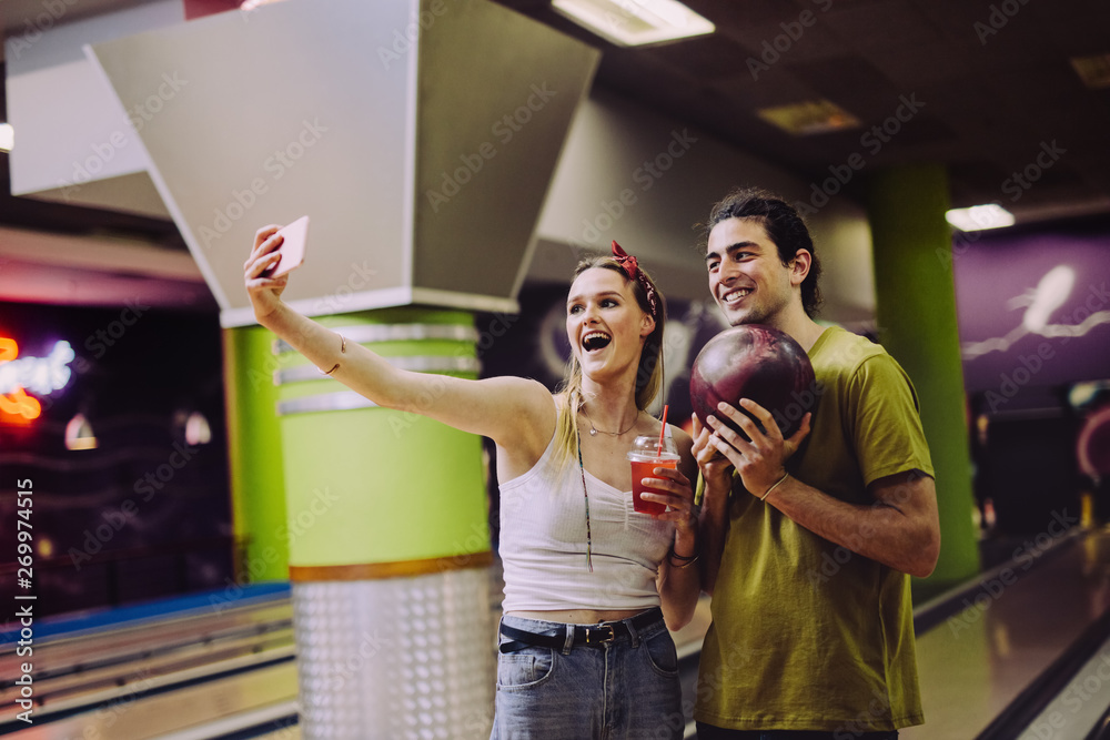 Couple taking selfie at bowling alley