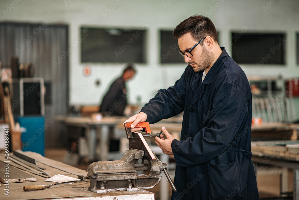 在金属工业工厂的车间里工作的男人。