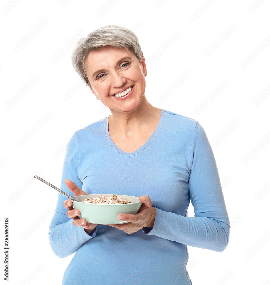 Mature woman with bowl of oatmeal on white background