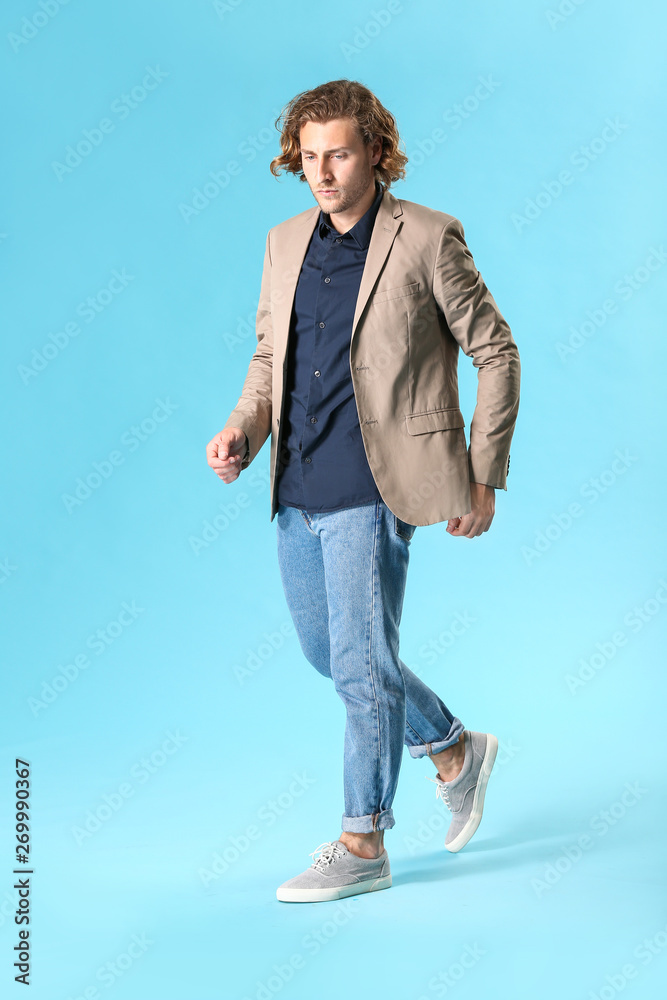 Stylish young man in casual clothes on color background