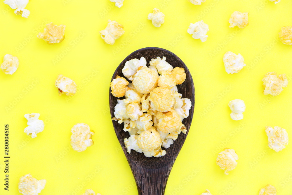 Top view isolated salted popcorn mix with cheese mushroom popcorn on wood ladle on yellow table back