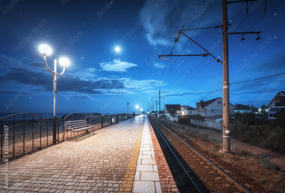 Beautiful railway station at night in summer. Starry sky over railroad at dusk. Industrial landscape